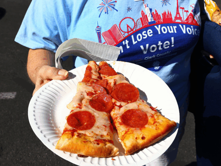 Pizza to the Polls woman in line to vote holding pizza