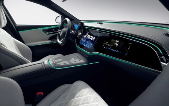 interior of a Mercedes car with a large screen embedded in the dash showing TikTok