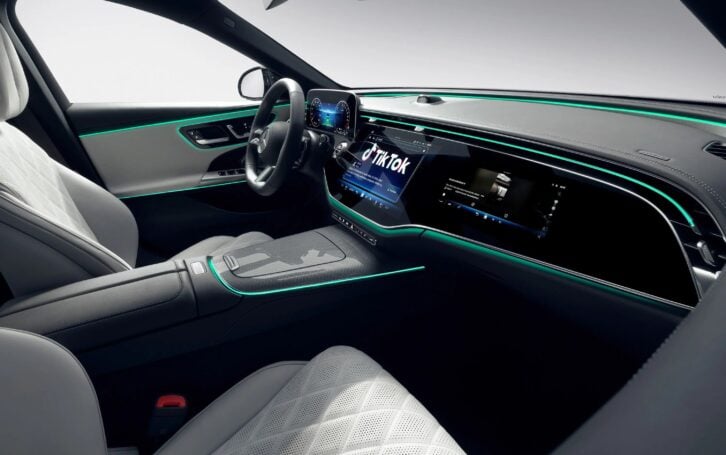 interior of a Mercedes car with a large screen embedded in the dash showing TikTok