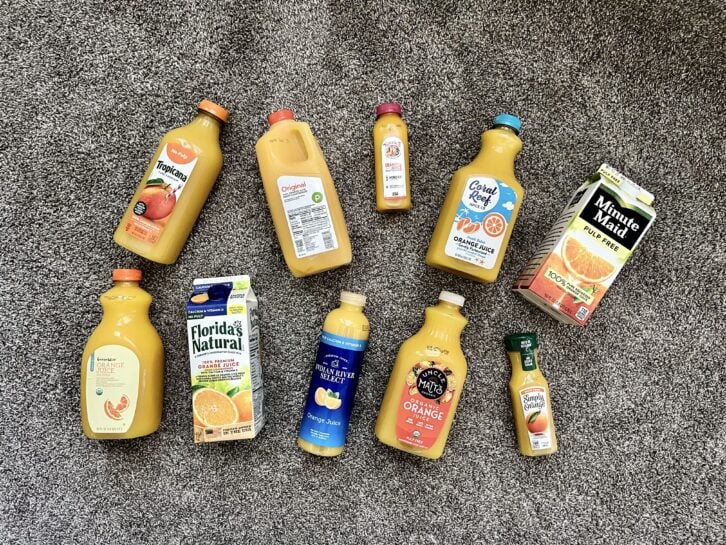 10 orange juices laying out on the ground