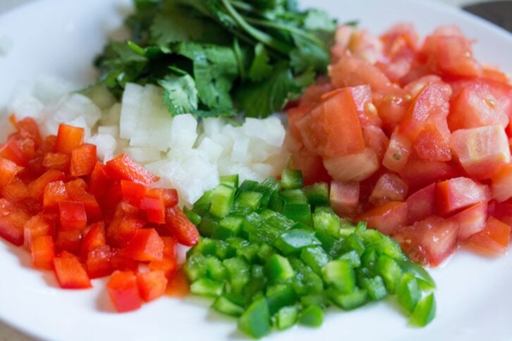a photo of chopped tomato, onion, cilantro, and peppers