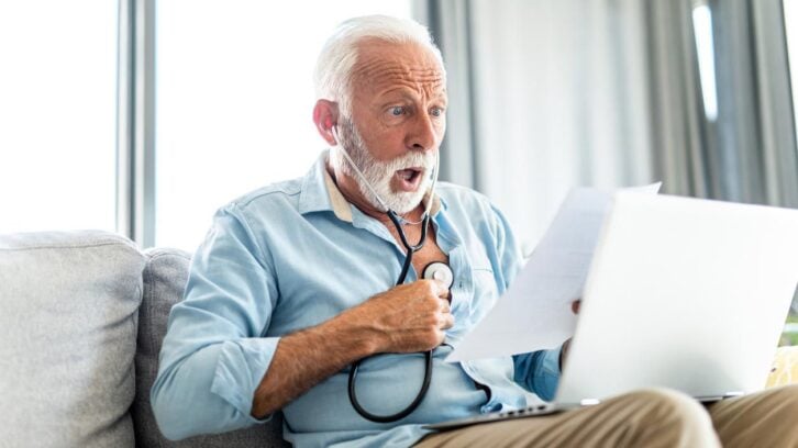 Shocked senior man reading a medical bill