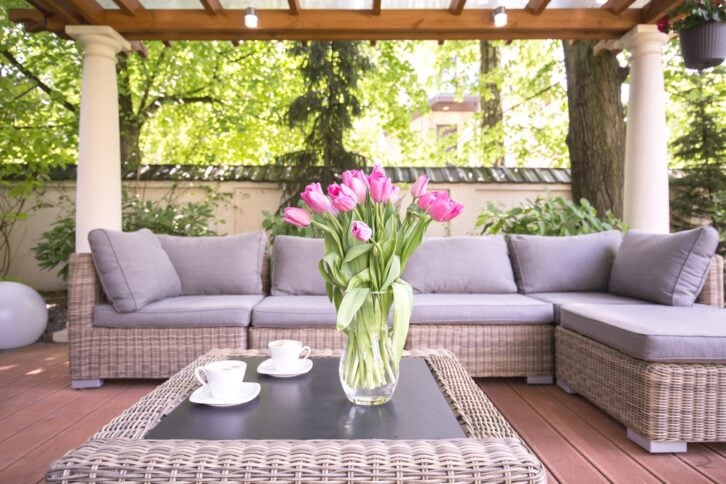Patio furniture in a modern garden with bright pink flowers