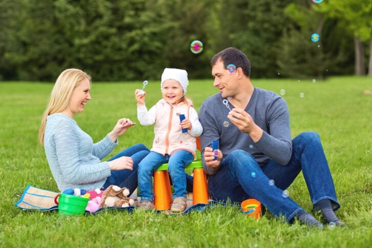 Family playing with bubbles outdoors