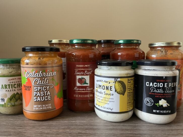 bottles of different trader joes pasta sauce lined up next to each other