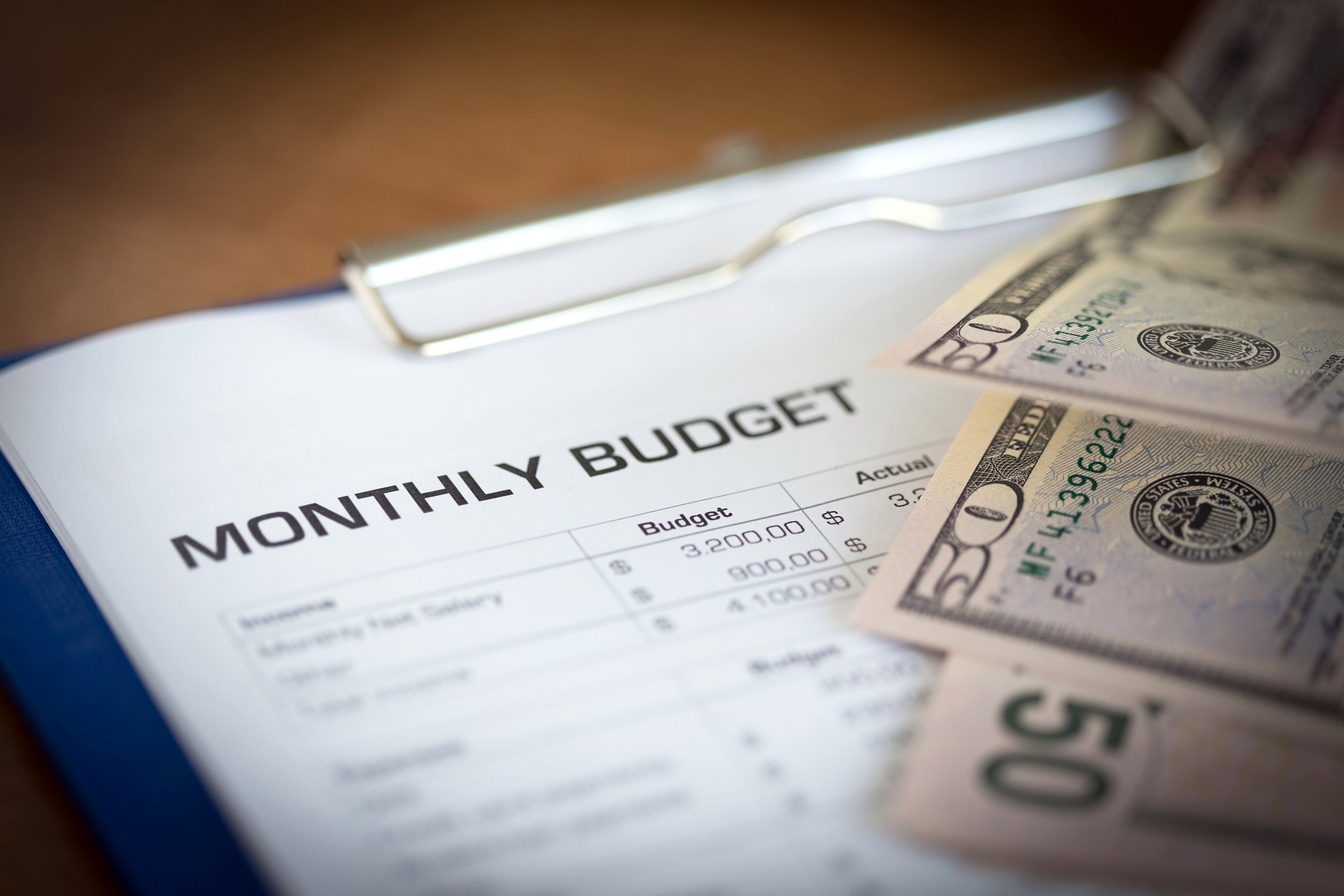 Monthly budget document next to money