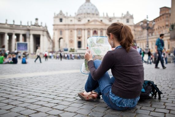 Woman sitting outside of St. Petersburg Square using a map