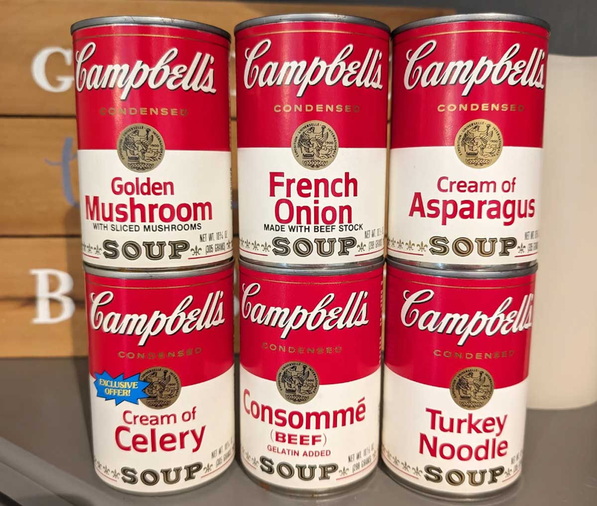 Six Campbell’s soup cans stacked in two rows, featuring popular 1980s flavors like Golden Mushroom, French Onion, Cream of Asparagus, Cream of Celery, Beef Consommé, and Turkey Noodle.
