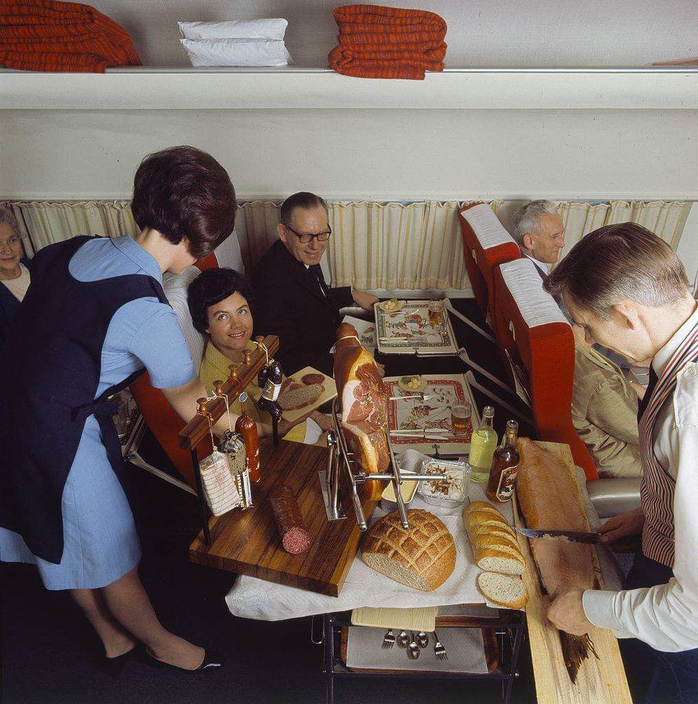 Air hostess and steward serving food on a Scandinavian Airlines flight in 1969