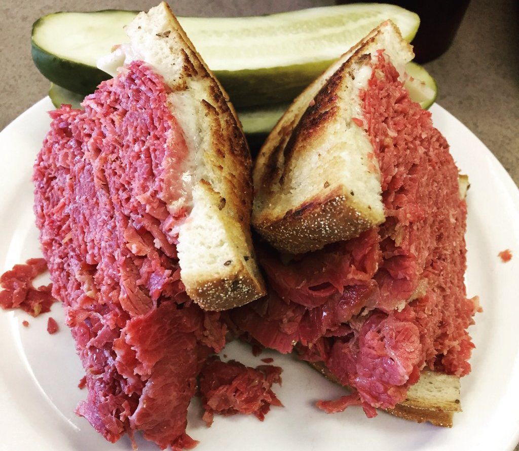 corned beef sandwich on stack of plates