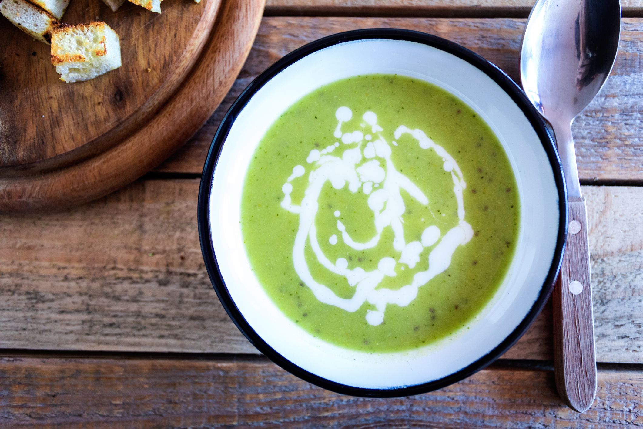 Vegetarian food - Creamy broccoli soup with yogurt in small metal plate at table, ready to eat
