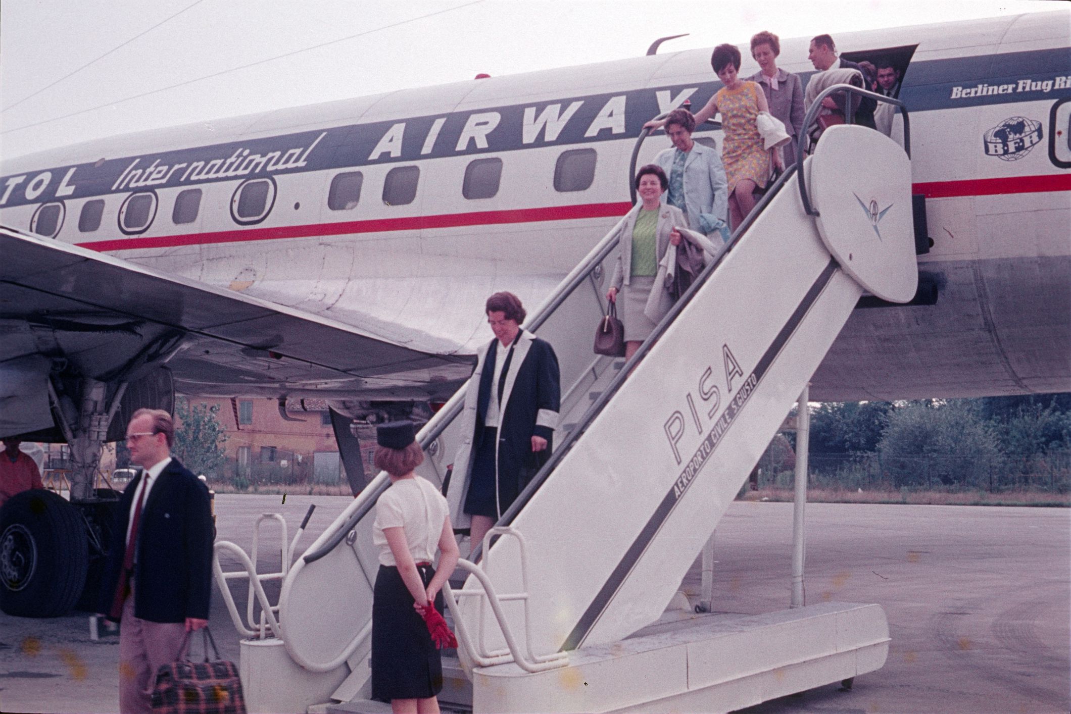 Pisa, Tuscany, Italy, 1967. Arrival of a passenger plane at Pisa Airport. Passengers leave the aircraft via a gangway.