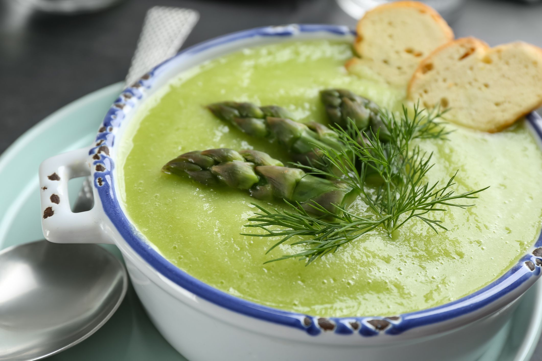 Delicious asparagus soup served in bowl, closeup