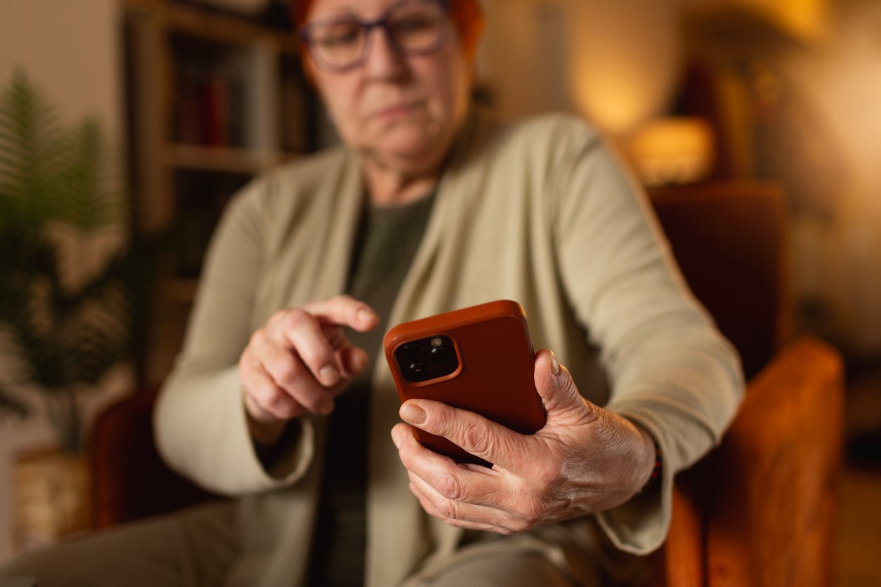 The senior woman is busy using her smartphone