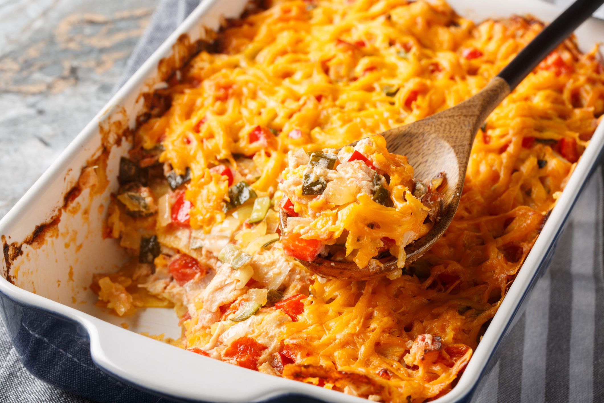 King Ranch Chicken Casserole is a Southern Texas staple dish close-up in a baking dish on a marble table. Horizontal