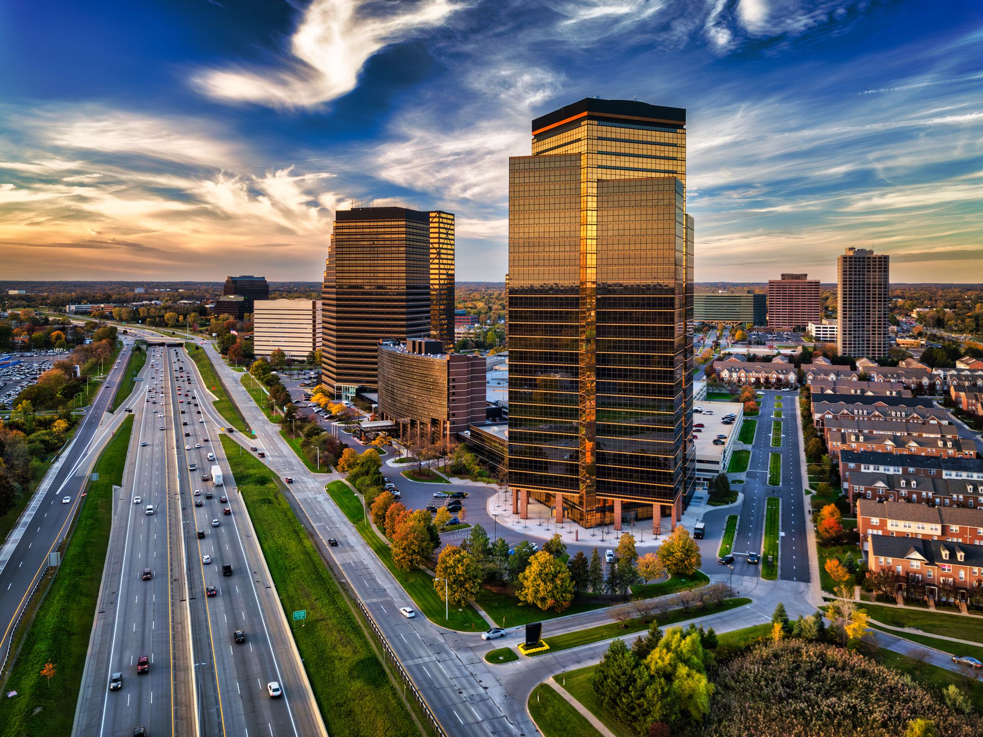 Skyline view of Southfield, MI in the Detroit metropolitan area during the golden hour, with a beautiful cloudscape in the background and the John C Lodge freeway and highrise buildings in the foreground.