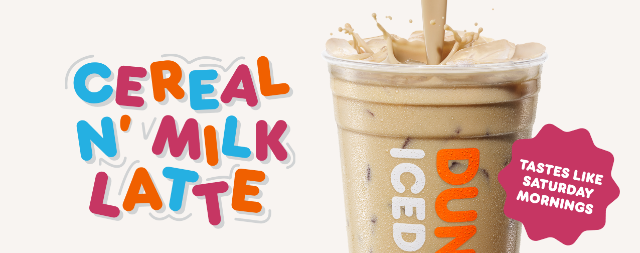 A cup of iced latte with milk being poured in, next to colorful text that reads "Cereal N' Milk Latte" and a pink badge stating "Tastes like Saturday mornings," inspired by your favorite new fast-food flavors.