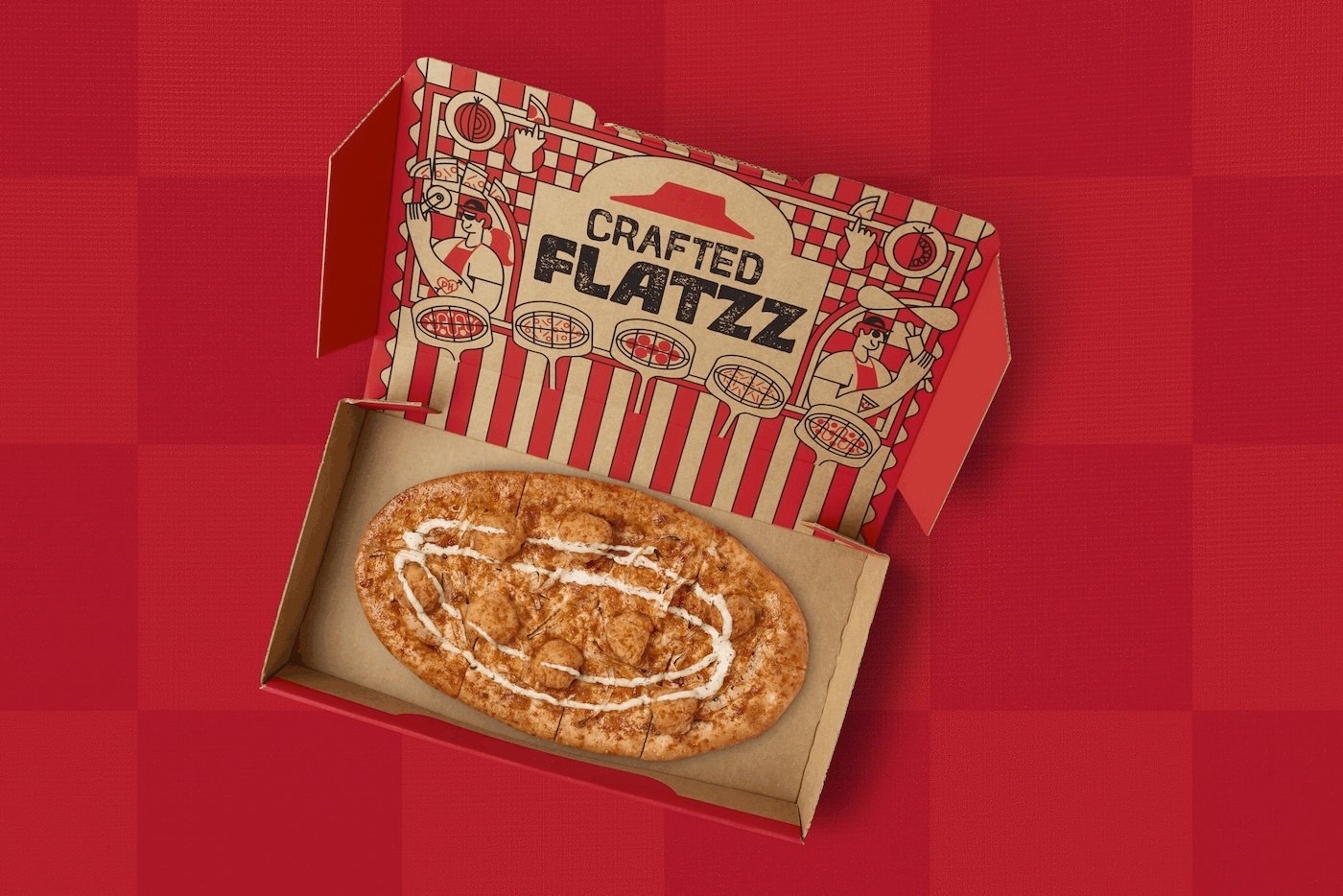 A new fast-food favorite, this rectangular flatbread with icing drizzled on top sits in an open cardboard box labeled "Crafted Flatzza," placed against a red checkered background for Pizza Hut.