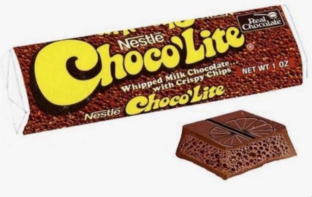 A Nestle Choco'Lite chocolate bar in its wrapper, with a section of the chocolate showing its bubbly, crisp interior and a circular pattern on top.