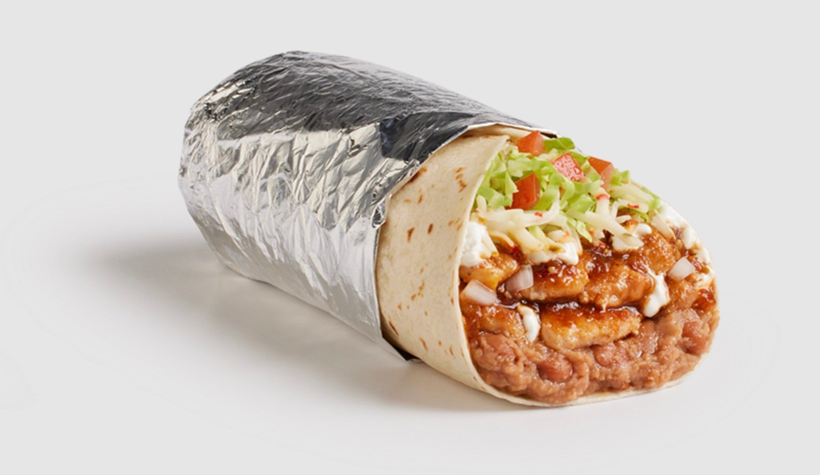 A new fast-food burrito wrapped in foil with visible beans, shredded lettuce, diced tomatoes, cheese, sauce, and pieces of meat inside a flour tortilla, set against a plain white background.
