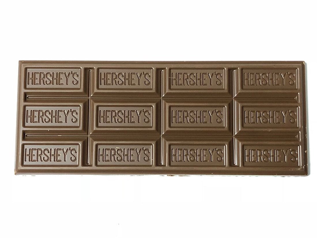 A Hershey's milk chocolate bar with twelve rectangular pieces, each piece embossed with the word "HERSHEY'S" on a light brown chocolate surface.