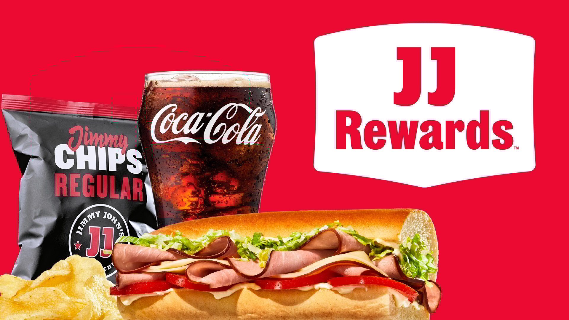 A sub sandwich with lettuce, tomato, and meat is in front of a glass of Coca-Cola and a bag of Jimmy Chips. The background is red with a white JJ Rewards logo on the right side.