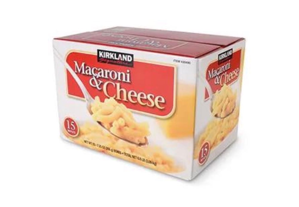 A box of Costco Kirkland Signature Macaroni & Cheese featuring a bowl of macaroni with cheese sauce on the front. The package advertises 15 servings and has a red and white design.