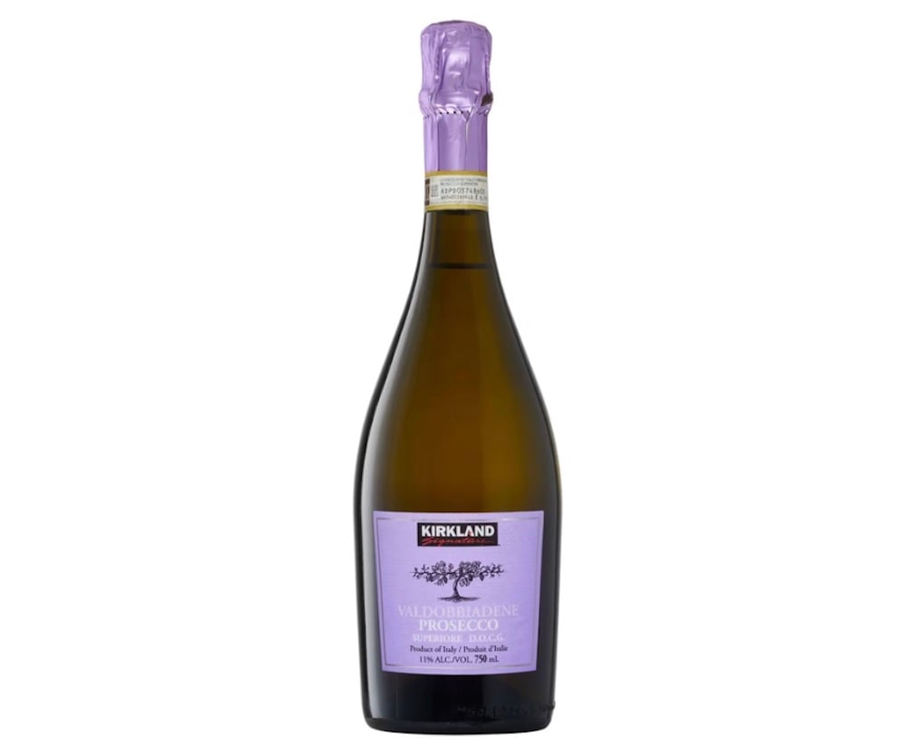 A bottle of Kirkland Valdobbiadene Prosecco with a purple foil top and a matching purple label on the front, set against a white background.