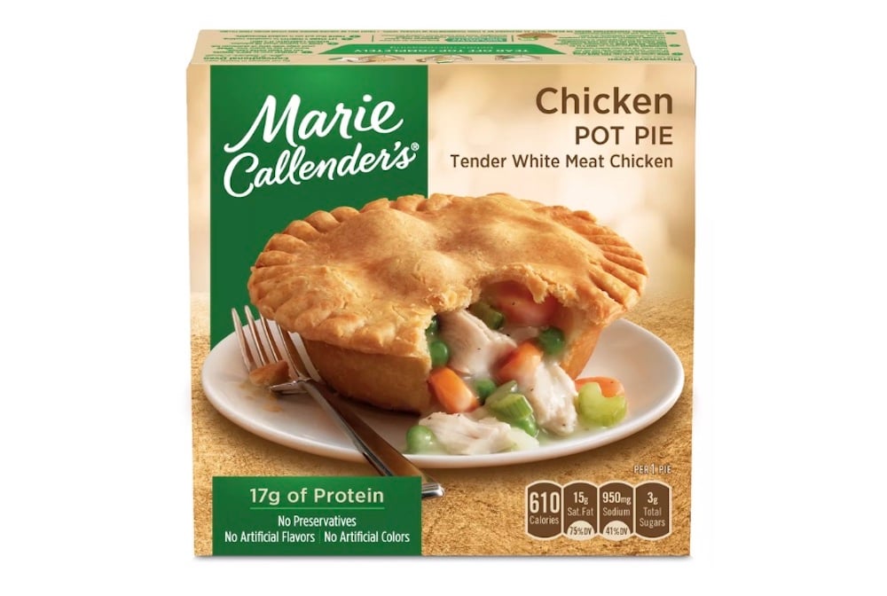 A box of Marie Callender's Chicken Pot Pie is shown, featuring an image of a baked pot pie with filling of chicken and vegetables on a plate. Nutrition facts and product details are displayed on the packaging.