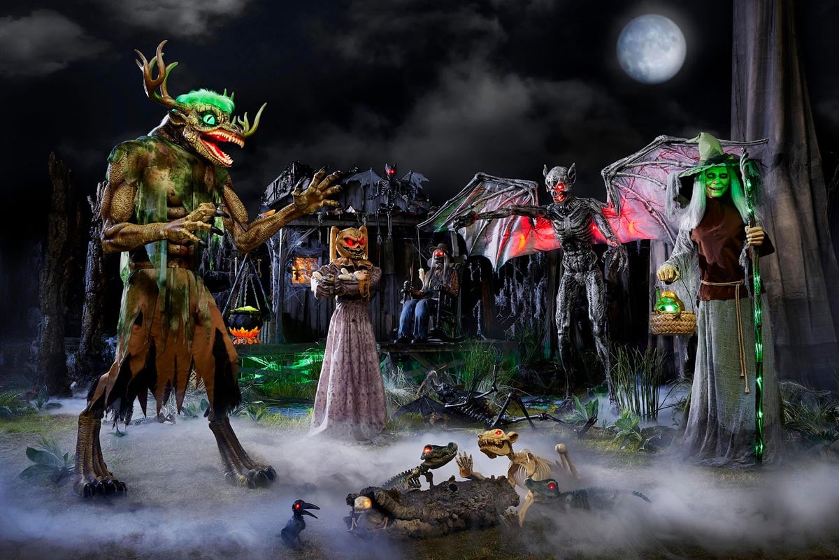 A spooky Halloween scene with eerie fog features monsters: a green antlered beast, a jack-o'-lantern figure, a bat-winged demon, and a witch with a glowing staff. Skeleton animals roam the foreground under a full moon.