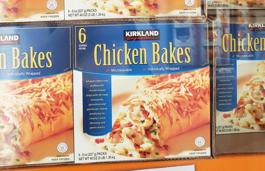 A box of Kirkland Signature Chicken Bakes showing an image of a golden-brown pastry filled with chicken, cheese, and vegetables. The packaging notes it is microwavable and contains 6 individually wrapped bakes.