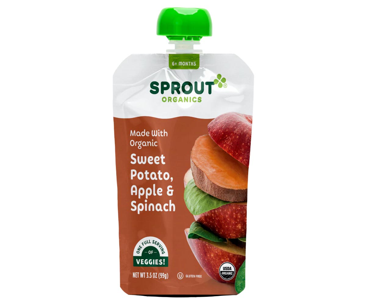 A pouch of Sprout Organics baby food with a green cap, labeled "Sweet Potato, Apple & Spinach." The packaging shows images of sweet potato slices, apple, and spinach leaves. The pouch is 3.5 oz and USDA organic certified.