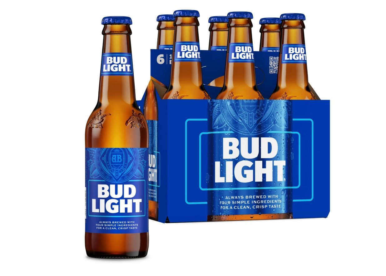 Six-pack of Bud Light beer bottles with blue and white labels and packaging, featuring one bottle displayed in front and the others in a cardboard carrier.