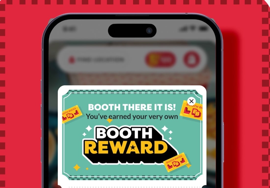 A smartphone screen displays a pop-up message that says "Booth there it is! You've earned your very own Booth Reward" with two ticket illustrations and a close button. The background is red with a checkered border.