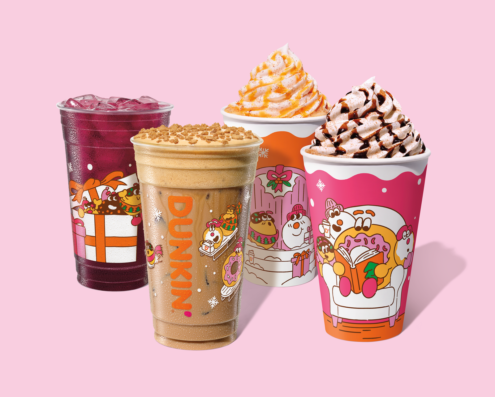 Four colorful Dunkin’ drinks from the new fast-food menu in holiday-themed cups with cartoon illustrations. Two have whipped cream and drizzle, one is an iced berry drink, and one blended beverage has a crumb topping. Pink background.