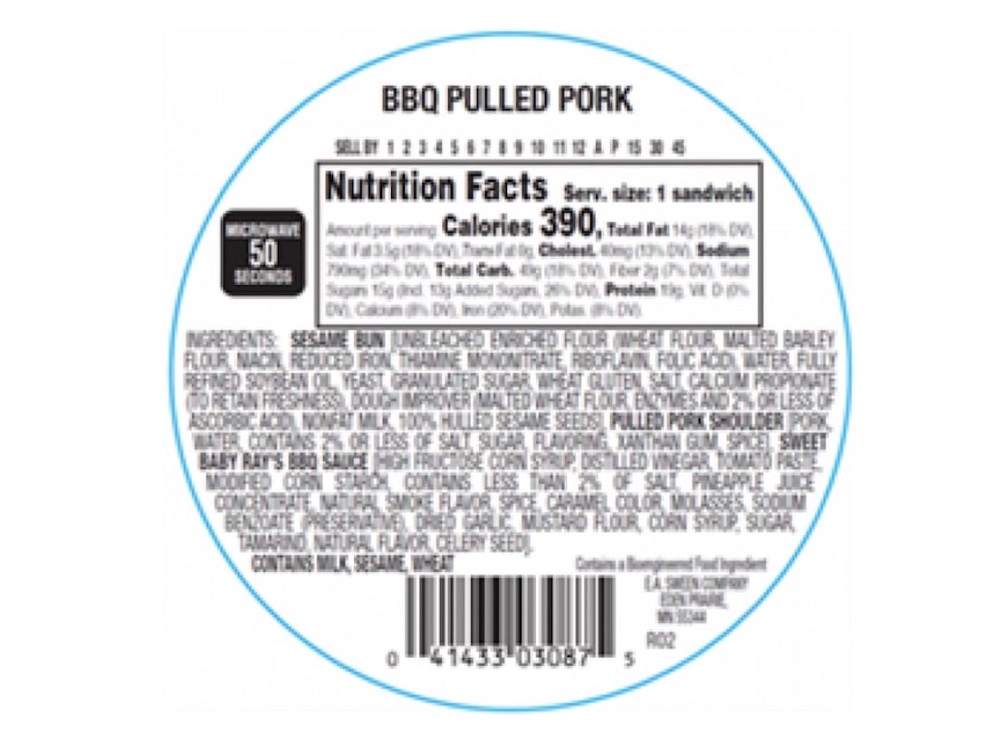 A circular food label for BBQ Pulled Pork shows nutrition facts, ingredients, and a barcode. Calorie and fat values are listed; a microwave symbol indicates 50 seconds heating time. The label is blue and white.