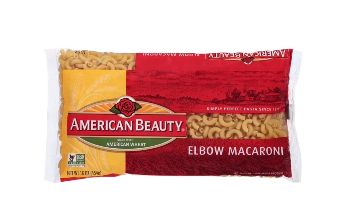 A 16-ounce package of American Beauty Elbow Macaroni pasta, featuring a red and yellow label with a rose logo and clear section showing the pasta inside.