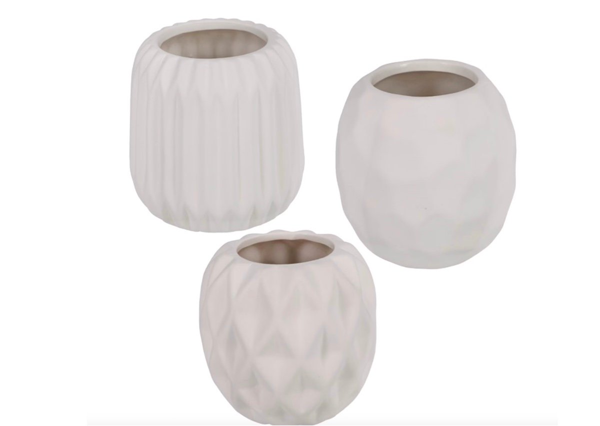 Three small white ceramic vases, each with a different textured pattern, are grouped together against a plain white background.