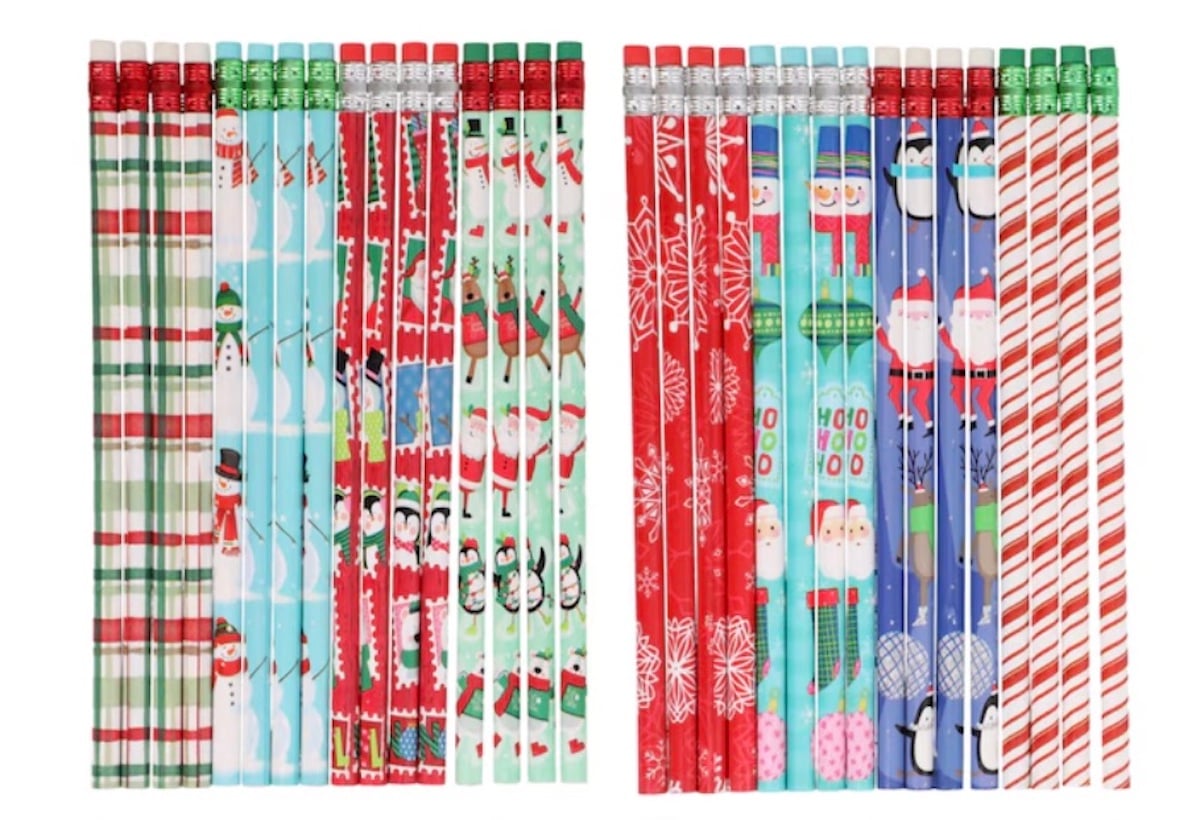 A collection of colorful pencils with festive designs, including snowmen, penguins, Santa Claus, snowflakes, and red, green, and white holiday patterns, arranged in two neat rows.