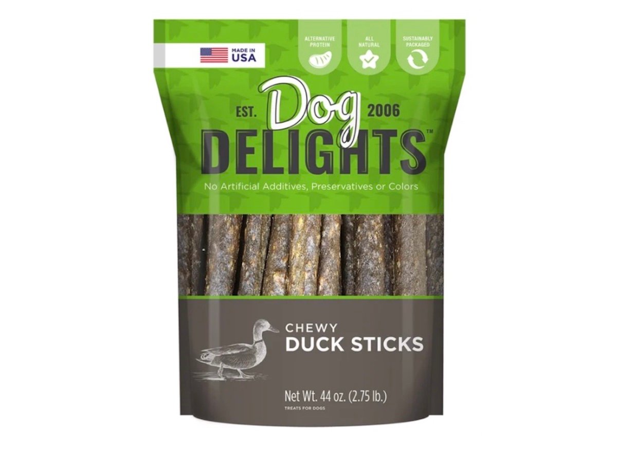 A bag of Dog Delights Chewy Duck Sticks dog treats, featuring green and brown packaging with a duck illustration, labeled as made in the USA, with no artificial additives, preservatives, or colors.