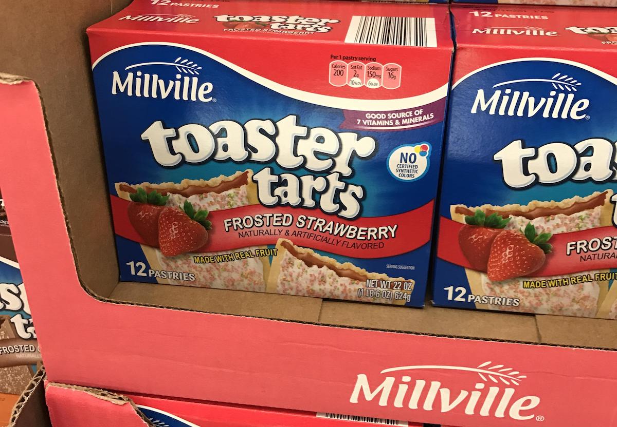 Two boxes of Millville Toaster Tarts Frosted Strawberry pastries are displayed in a pink cardboard box. The packaging shows images of the pastries and strawberries, and highlights that it contains 12 pastries per box.