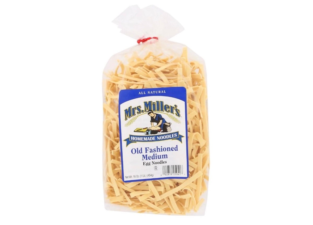 A clear plastic bag of Mrs. Miller's Homemade Noodles, labeled "Old Fashioned Medium Egg Noodles," with yellow noodles visible inside and a blue and white label on the front.