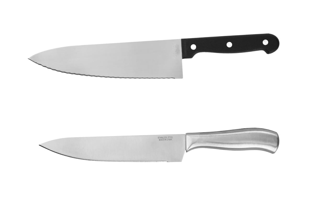 Two kitchen knives side by side on a white background; the top knife has a black handle and a serrated blade, while the bottom knife has a metal handle and a straight-edged blade.