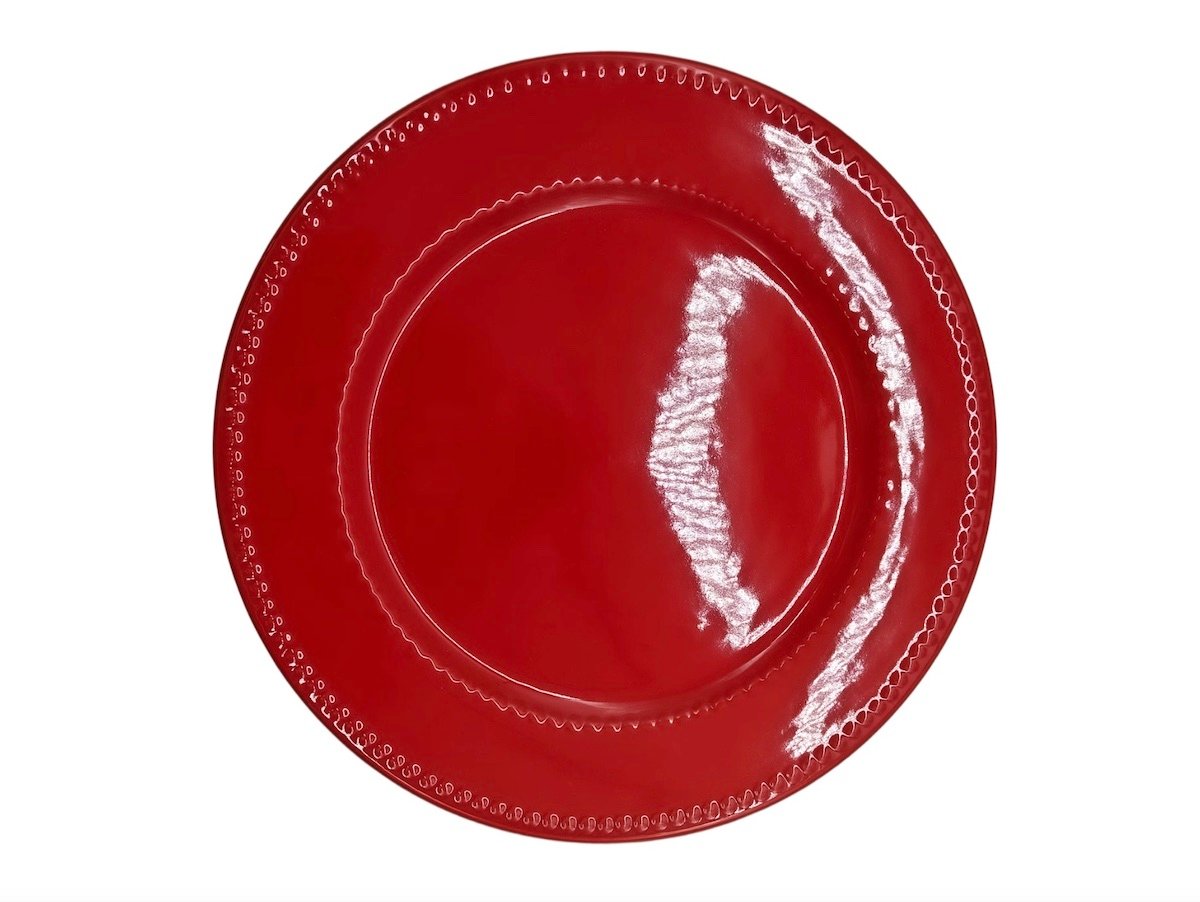 A shiny red plate with a decorative, beaded edge, viewed from above on a white background.