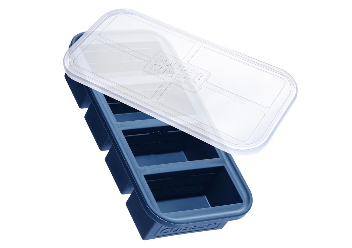 A blue silicone Souper Cubes tray with four large rectangular compartments and a clear plastic lid, shown partially open.