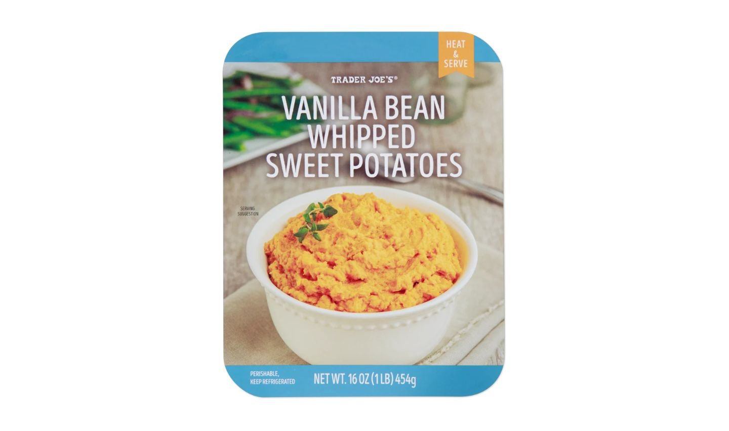 A package of Trader Joe's Vanilla Bean Whipped Sweet Potatoes features a bowl of orange whipped sweet potatoes garnished with herbs on a light-colored surface. The label shows product name, weight, and serving instructions.