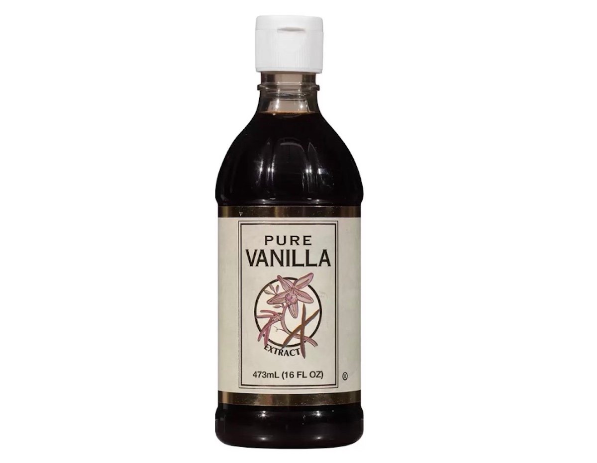 A bottle of pure vanilla extract with a white cap and a beige label featuring a vanilla flower illustration. The bottle contains 473 mL (16 fl oz) of vanilla extract.