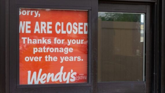 A red sign in a window reads, "Sorry, WE ARE CLOSED. Thanks for your patronage over the years. Wendy’s.