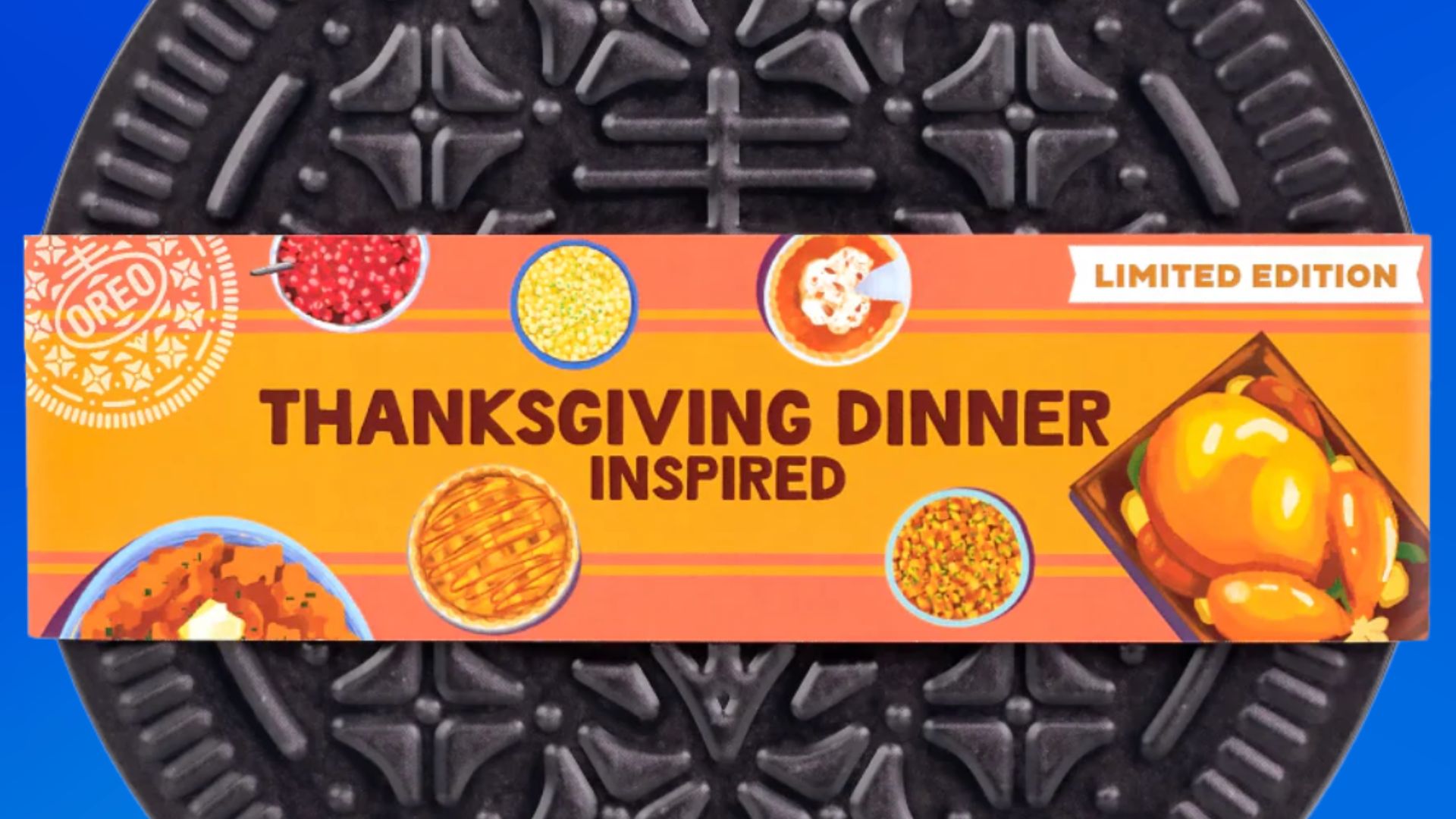 A close-up of an Oreo cookie package labeled "Thanksgiving Dinner Inspired" with images of turkey, pumpkin pie, cranberry sauce, corn, mashed potatoes, and green beans on an orange background.