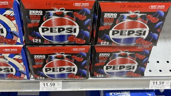 Twelve-pack boxes of Pepsi Zero Sugar Wild Cherry soda are stacked on a store shelf. Each box features the Pepsi logo, images of cherries, and the price tag below reads $11.59.
